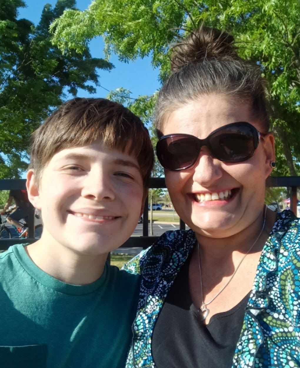 Crystal smiling outdoors with her son