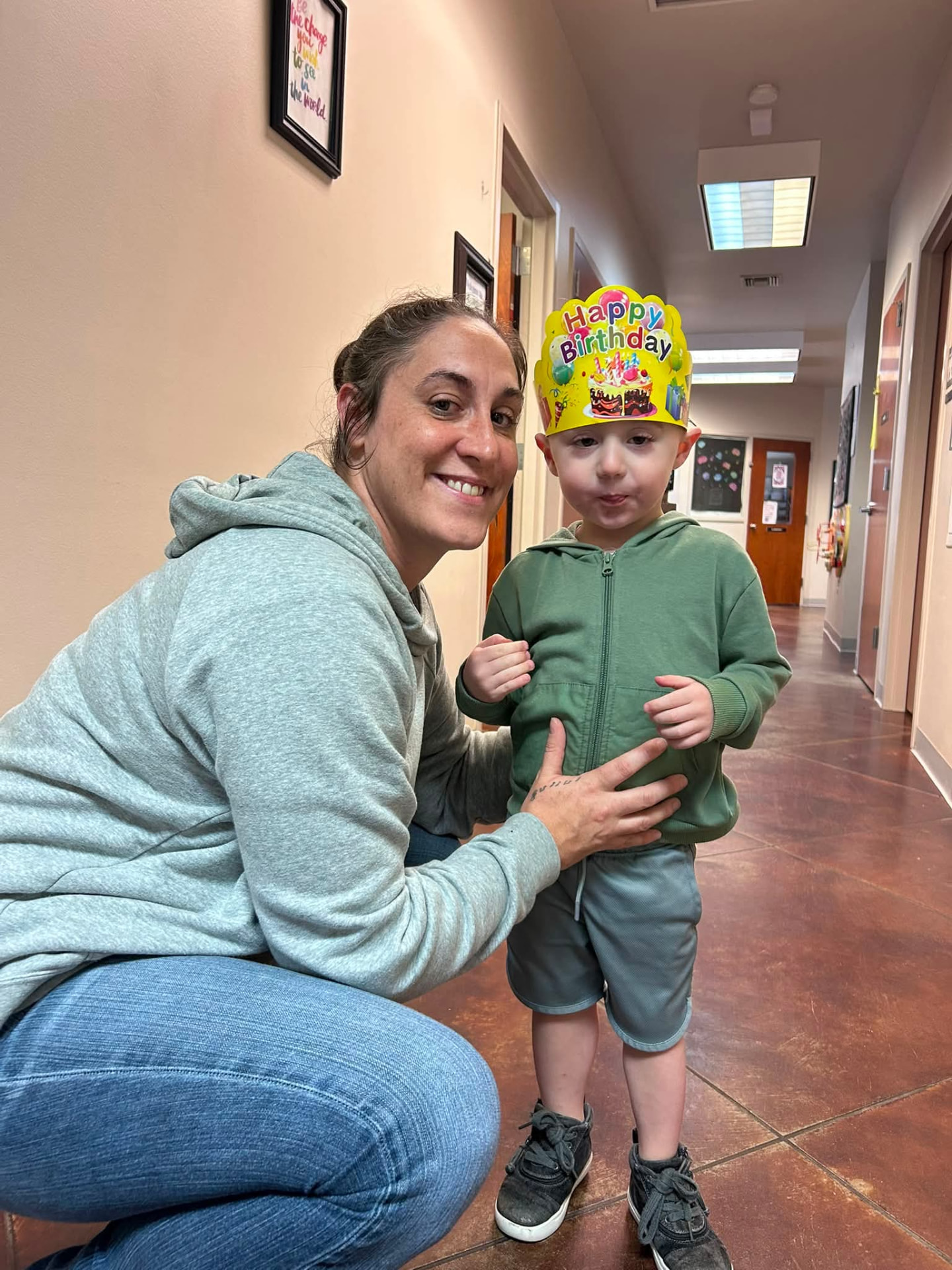 Whitney kneeling beside her son Blake, who is wearing a birthday crown