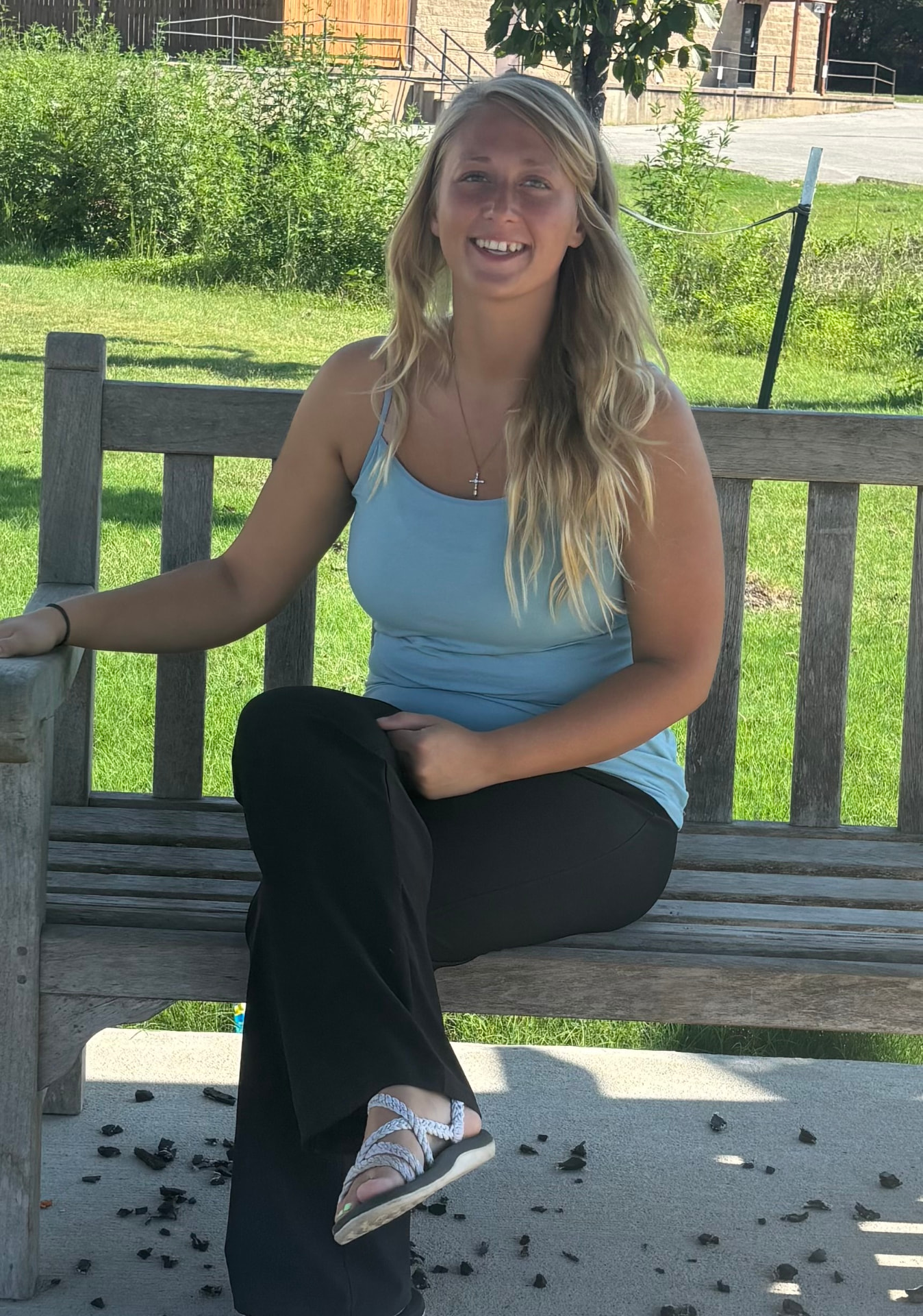 Acacia smiling while sitting on a wooden bench outdoors